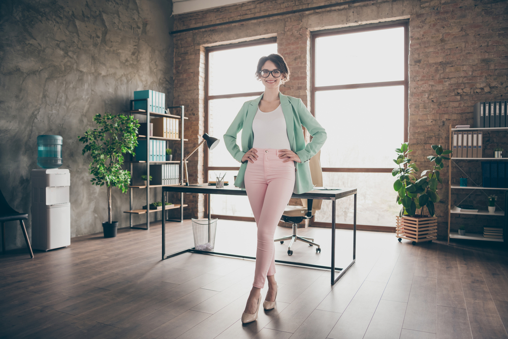 Girl in pink high-waisted pants in office.